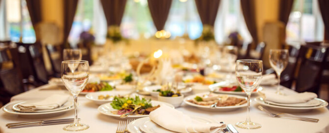 Wedding table in the restaurant decorated with white candles and flowers.