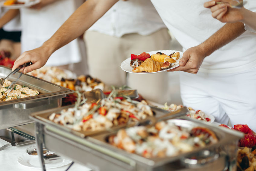 Guests putting food on plates at a catered buffet